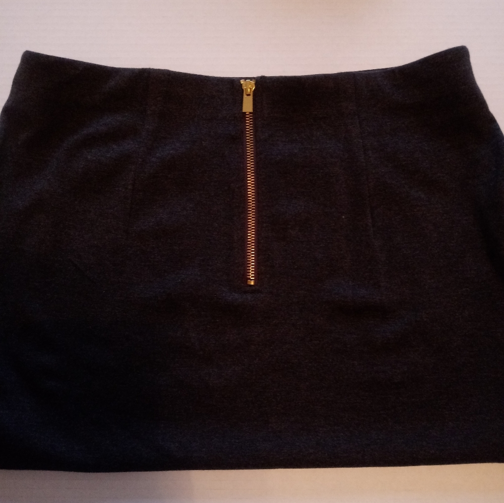 Casual clothing, dark gray skirt.